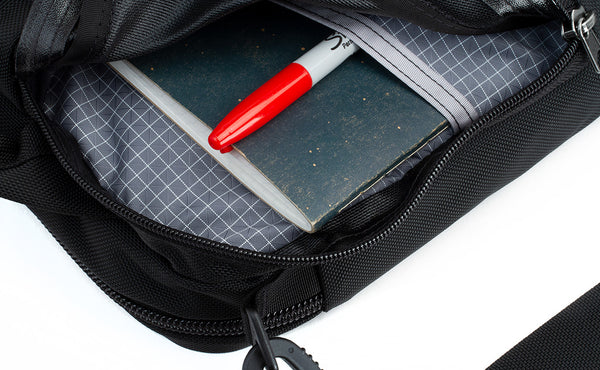The side compartment of the Pilot with a notepad and marker inserted into the interior pocket.